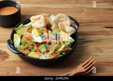 Gado-gado Betawi. Traditioneller Gemüsesalat mit Erdnussdressing aus Betawi, Jakarta. Serviert in einer schwarzen Keramikplatte Stockfoto