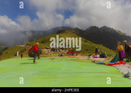 Schöne Aussicht auf Touristen, die Gleitschirmfliegen in Bir, Kangra, Himachal Pradesh in Indien genießen. Stockfoto