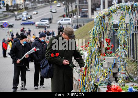 Kiew, Ukraine. 20th. Februar 2022. Die Ukrainer halten Blumen bereit, während sie den „Himmlischen Hundert“ in der Allee der Himmlischen Hundert Helden während einer Zeremonie zu Ehren der toten Ukrainer ihren Respekt zollen. Am 20. Februar fanden in Kiew auf dem Unabhängigkeitsplatz Veranstaltungen zu Ehren der Ukrainer statt, die in diesen Tagen vor acht Jahren während der regierungsfeindlichen Proteste von 2013 bis 2014 ums Leben kamen. (Foto: Sergei Chuzavkov/SOPA Images/Sipa USA) Quelle: SIPA USA/Alamy Live News Stockfoto