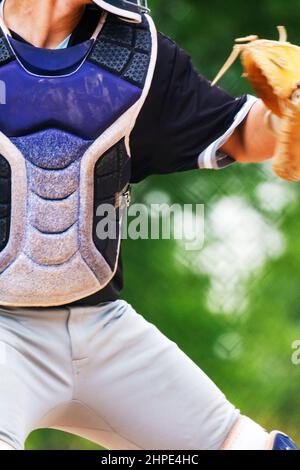 Der mittlere Körper eines Fängers, der den Ball zurück in den Pitcher wirft. Stockfoto