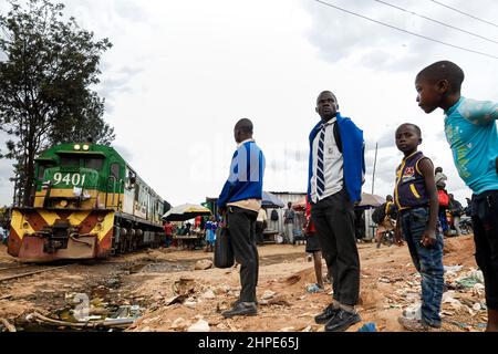 Nairobi, Kenia. 18th. Februar 2022. Die Studenten warten, als sich ein Zug dem provisorischen Bahnhof in den Slums von Kibera nähert. Kredit: SOPA Images Limited/Alamy Live Nachrichten Stockfoto