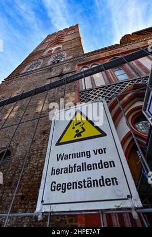 15. Februar 2022, Brandenburg, Frankfurt (oder): An einem Bauzaun vor der Marienkirche im Zentrum der deutsch-polnischen Grenzstadt ist ein Schild mit der Aufschrift "Warnung vor fallenden Objekten" angebracht. Die imposante Marienkirche ist die größte mittelalterliche Kirche Brandenburgs und ein Wahrzeichen Frankfurts. Erst nach dem Fall der Berliner Mauer wurden die Ruinen zu einem fast vollständigen Sakralbau mit dem besonderen Schatz einer glasbilderbibel restauriert. Aber das Denkmal bleibt ein Fall der Umgestaltung. (To dpa: 'Wenn das mittelalterliche Wahrzeichen zerfällt') Foto: Patrick Pleul/dpa-Zent Stockfoto