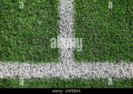 Ein Teil des Fußballfeldes aus der Nähe, künstliches grünes Gras mit weißen Randlinien, Astroturf im Stadion für Sportenspiele Stockfoto