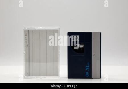 Vintage Mini DV-Videokassette mit Kassettenbox auf weißem Hintergrund. Retro-Style-Technologie aus dem Jahr 90s Stockfoto