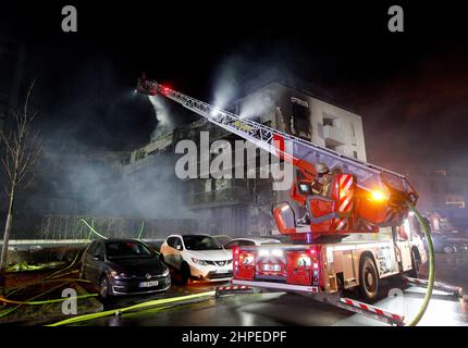 Essen, Deutschland. 21st. Februar 2022. Feuerwehrleute löschen einen Wohnblock, der aus noch unbekannten Gründen in Brand geraten war. Etwa 100 Menschen lebten in dem Mehrfamilienhaus. Quelle: Roland Weihrauch/dpa/Alamy Live News Stockfoto