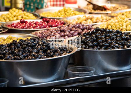 Ein Verkaufsstand, der verschiedene Sorten heimischer Oliven nach Gewicht auf dem Markt verkauft. Nahaufnahme Stockfoto