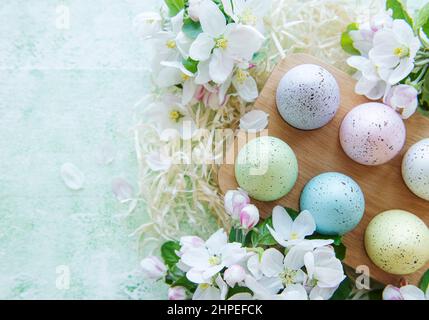 Frohe Ostern, Öko-Konzept. Ostereier in Holzschale auf grünem Holzhintergrund Stockfoto