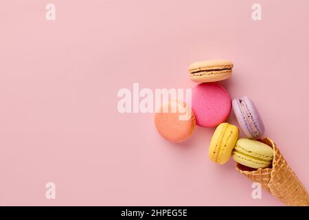 Bunte leckere Makronen oder Makronen in einem Eiswaffelkegel. Sommerliches Dessert-Konzept. Stockfoto