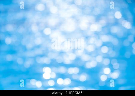 Defokussiertes, reines blaues Wasser im Swimmingpool mit Lichtreflexionen. Wasser Swimmingpool Oberfläche Sommerzeit Hintergrund Stockfoto