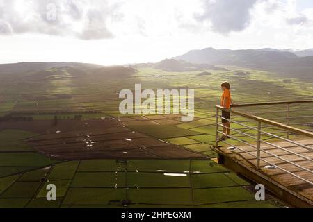 Junge mit Blick auf die weite Ebene, Panoramablick vom Miradouro da Serra do Cume auf Terceira Island, Azoren-Archipel, Portugal Stockfoto