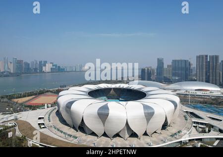 Hangzhou, Hangzhou, China. 21st. Februar 2022. Am 21. Februar 2022 wurde das Hangzhou Olympic Sports Center, der Hauptveranstaltungsort der Asienspiele 2022, aus der Vogelperspektive betrachtet.das Hangzhou Olympic Sports Center, auch als „Hangzhou Olympic Sports Center“ bezeichnet, Befindet sich am Südufer des Qiantang River in Hangzhou City und dem Kerngebiet der Hangzhou Olympic Sports Expo City. Das Sportzentrum besteht hauptsächlich aus Stadion (großer Lotus), Gymnasium/Natatorium (huadie), Tenniszentrum (kleiner Lotus), umfassender Trainingshalle (Yucong), usw. Es kann Welt- und interkontinentale umfassende Sportspiele abhalten. (C Stockfoto