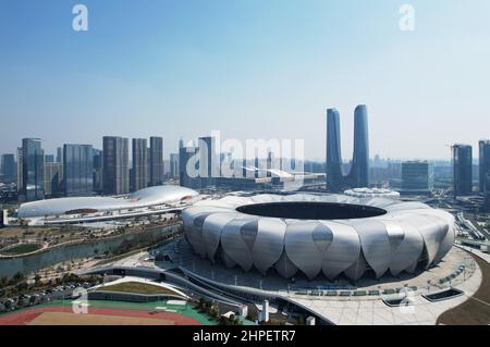 Hangzhou, Hangzhou, China. 21st. Februar 2022. Am 21. Februar 2022 wurde das Hangzhou Olympic Sports Center, der Hauptveranstaltungsort der Asienspiele 2022, aus der Vogelperspektive betrachtet.das Hangzhou Olympic Sports Center, auch als „Hangzhou Olympic Sports Center“ bezeichnet, Befindet sich am Südufer des Qiantang River in Hangzhou City und dem Kerngebiet der Hangzhou Olympic Sports Expo City. Das Sportzentrum besteht hauptsächlich aus Stadion (großer Lotus), Gymnasium/Natatorium (huadie), Tenniszentrum (kleiner Lotus), umfassender Trainingshalle (Yucong), usw. Es kann Welt- und interkontinentale umfassende Sportspiele abhalten. (C Stockfoto