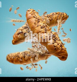 Frisch gebackene Brötchen fliegen in der Luft. Kreatives Frühstückskonzept. Stockfoto