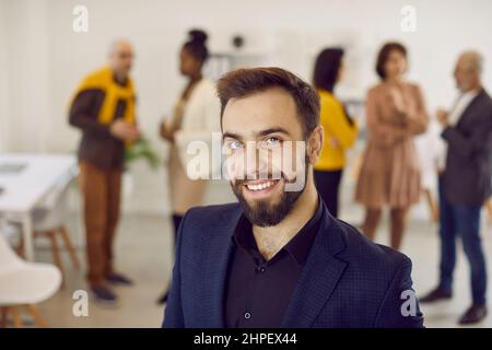 Porträt eines gutaussehenden und erfolgreichen Geschäftsmannes mit Bürohintergrund im modernen Business Center. Stockfoto