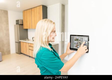 Frau zu Hause mit intelligenten Thermostat, Automatisierung häusliche System Stockfoto