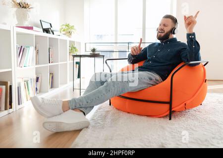 Mann, Der Musik Zuhört Und Kopfhörer Trägt, Der Zu Hause Sitzt Stockfoto