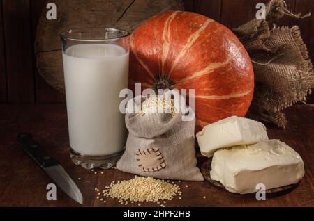 Kürbis, Hirse und andere Zutaten für Kürbisbrei auf dunklem Grund Stockfoto