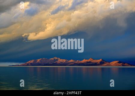 Das warme Licht der untergehenden Sonne leuchtet auf der Westseite von Antelope Island mit dem Great Salt Lake im Vordergrund, westlich von Salt Lake City, Utah. Stockfoto