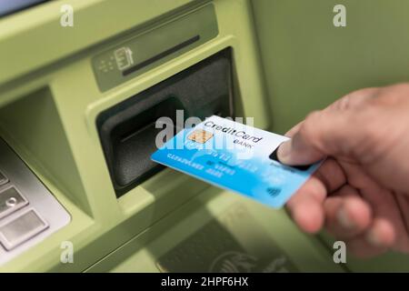 afro-amerikanischer Mann Hand legt Kreditkarte in ATM Stockfoto