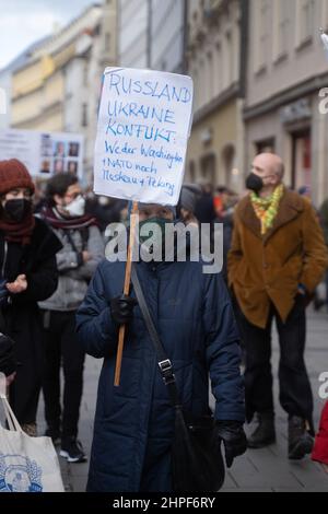 München, Deutschland. 19th. Februar 2022. Teilnehmer mit Zeichen „Russland-Ukraine-Konflikt: Weder Washington nato noch Moskau Peking“. Am 19. Februar 2022 versammelten sich Tausende von Teilnehmern, um gegen die Münchner Sicherheitskonferenz, gegen Krieg und NATO und für den Frieden zu demonstrieren. In diesem Jahr werden auf der MSC Themen wie der Russland-Ukraine-Konflikt behandelt, ohne dass Russland daran teilnimmt. (Foto: Alexander Pohl/Sipa USA) Quelle: SIPA USA/Alamy Live News Stockfoto