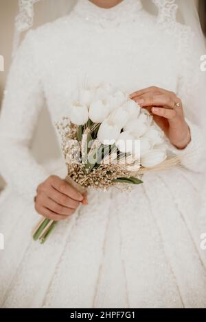 brautblume in der Hand der Braut, fokussiert auf eine Hand und Tulpe Stockfoto