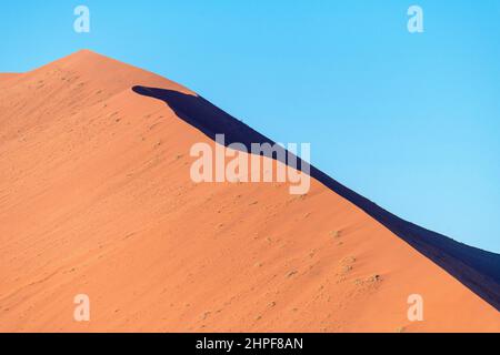 Große natürliche duna in der sonnigen Wüste auf dem blauen Himmel Hintergrund, heißes Namibia. Stockfoto