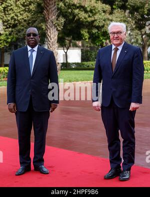 Dakar, Senegal. 21st. Februar 2022. Bundespräsident Frank-Walter Steinmeier (r) wird von dem senegalesischen Präsidenten Macky Sall im Präsidentenpalast mit militärischen Ehren begrüßt. Präsident Steinmeier ist zu einem dreitägigen Besuch in der Westafrikanischen Republik Senegal. Quelle: Bernd von Jutrczenka/dpa/Alamy Live News Stockfoto