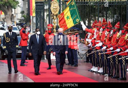 Dakar, Senegal. 21st. Februar 2022. Bundespräsident Frank-Walter Steinmeier (r) wird von dem senegalesischen Präsidenten Macky Sall im Präsidentenpalast mit militärischen Ehren begrüßt. Präsident Steinmeier ist zu einem dreitägigen Besuch in der Westafrikanischen Republik Senegal. Quelle: Bernd von Jutrczenka/dpa/Alamy Live News Stockfoto