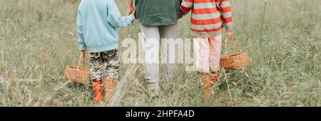 Kinder Pilzsammler gehen in den Wald oder Wald von der Hand mit ihrer Großmutter. Familie von Überlebenden sammelt wilden Pilz Ernte und im Freien Stockfoto