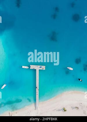 Weißer Sandstrand und Hafenpier mit transparentem blauem und türkisfarbenem Wasser, Luftaufnahme von oben von der Drohne auf der tropischen Insel der Malediven. Wunderschönes VA Stockfoto