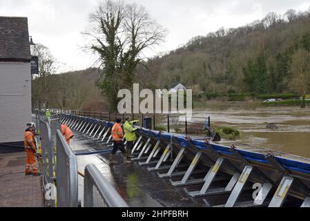 Ironbridge, Telford, Großbritannien. 21st. Februar 2022. Mitarbeiter der Umweltbehörde bereiten die Hochwasserabwehr in der Ironbridge Gorge vor, die an den Fluss Severn angrenzt.die übermäßigen Regenfälle der letzten Woche haben dazu geführt, dass der Fluss Severn sehr hohe Niveaus erreicht hat, die umliegenden Städte und die Landschaft überflutet haben und dass der Höhepunkt am Dienstagabend erwartet wird. G.P.Essex, Alamy Live Nachrichten Stockfoto