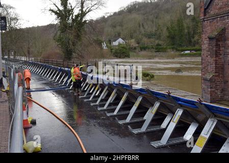 Ironbridge, Telford, Großbritannien. 21st. Februar 2022. Mitarbeiter der Umweltbehörde bereiten die Hochwasserabwehr in der Ironbridge Gorge vor, die an den Fluss Severn angrenzt.die übermäßigen Regenfälle der letzten Woche haben dazu geführt, dass der Fluss Severn sehr hohe Niveaus erreicht hat, die umliegenden Städte und die Landschaft überflutet haben und dass der Höhepunkt am Dienstagabend erwartet wird. G.P.Essex, Alamy Live Nachrichten Stockfoto