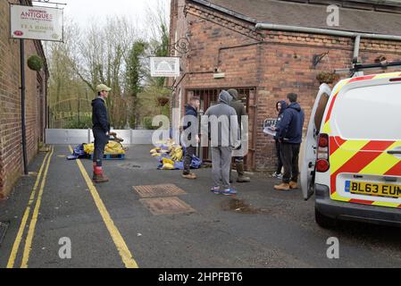 Ironbridge, Telford, Großbritannien. 21st. Februar 2022. Die Mitarbeiter von Ironbridge Interiors bereiten die Hochwasserschutzmaßnahmen vor, da der angrenzende Fluss Severn sich schnell in Richtung ihrer Werkstatt erhebt, die in den letzten zwei Jahren dreimal überflutet wurde. Die übermäßigen Niederschläge der letzten Woche durch Stürme haben dazu geführt, dass der Fluss Severn auf sehr hohe Niveaus ansteigt und die umliegenden Städte und das Land überflutet hat. Der Höhepunkt ist jedoch am Dienstagabend. G.P.Essex, Alamy Live Nachrichten Stockfoto