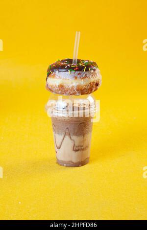 Donut Eisted Latte Shake mit bestreuttem Donut. Stockfoto