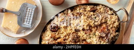 Pilzrisotto, rustikales Reisgericht Panorama, mit Zutaten, von oben auf einem hölzernen Hintergrund geschossen Stockfoto