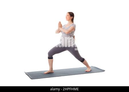 Schwangere beim Yoga Asana Virabhadrasana 1 Stockfoto