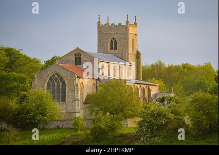 Die St. Mary the Virgin Kirche aus dem 14.. Jahrhundert in Wiveton bei Cley Next the Sea in Norfolk, England, Großbritannien, von der anderen Seite der Felder auf der Glandford Road aus gesehen Stockfoto