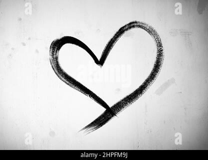 Konzept oder konzeptuell bemalte schwarze abstrakte Herzform Liebe Symbol, schmutzige Wand Hintergrund, Metapher für urbane und romantische valentine, grungy Stil Stockfoto