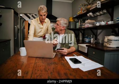 kaukasisches Seniorenpaar online einkaufen zu Hause Stockfoto