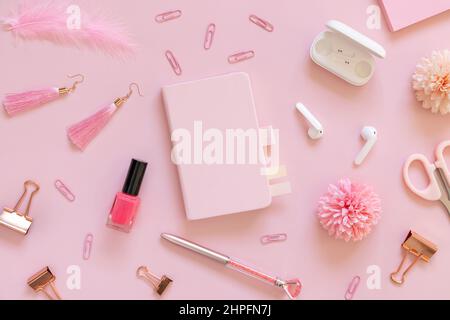 Hardcover-Notizbuch und rosa Schulzubehör auf pastellrosa, Draufsicht, Textbuch-Modell. Girly Arbeitsplatz mit Schere, Bleistifte, Stift, Büroklammern, Ohr Stockfoto