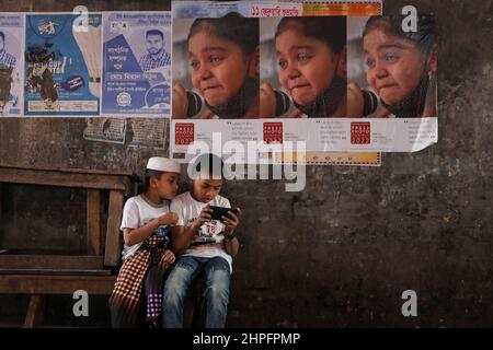 Dhaka, Bangladesch. 21st. Februar 2022. Kinder sehen Videos auf dem Mobiltelefon in Dhaka, Bangladesch. (Bild: © Kazi Salahuddin via ZUMA Press Wire) Stockfoto