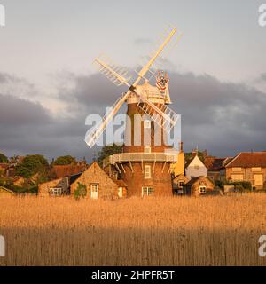 Am späten Nachmittag strahlte Sonnenschein die Windmühle in Cley am Meer entlang des Flusses Glaven an der Küste von Norfolk, England, auf Stockfoto