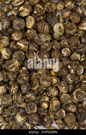 Jasmine Pearls Grüner Tee auf weißem Hintergrund. Medizinischer asiatischer Kräutertee. Nahaufnahme Stockfoto