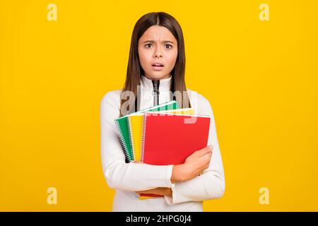 Foto von unglücklich verärgert Student Mädchen tragen weißen Reißverschluss Hemd lächelnd halten Buch Stapel hören schlechte Nachrichten isoliert gelbe Farbe Hintergrund Stockfoto