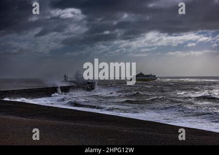 Newhaven Lighthouse, Großbritannien, 21st. Februar 2022. Eine Fähre, die den Hafen verlässt und am Leuchtturm von Newhaven vorbeifährt, während die Wellen auf die Meeresmauer treffen, während Sturm Franklin fegt, dachte an Teile der Südküste Englands. Quelle: Steven Paston/Alamy Live News Stockfoto