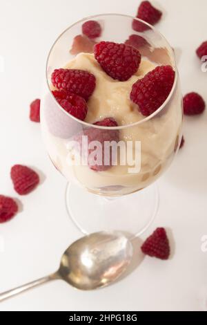 Creamed Grießpudding mit Himbeeren geeignet für Vegetarier in einem Weinglas serviert Stockfoto