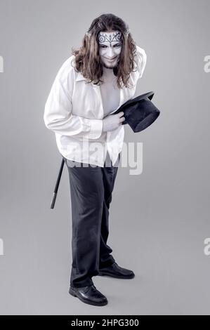 Fantasy Illusionist Performer. Body bemalt Performer in schwarz-weißem Anzug mit Hut und Stick Stockfoto