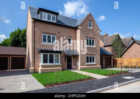 Harston Cambridgeshire - Juni 29 2011: Generische traditionellen Stil Backstein gebaut neue Haus Fassade mit Rasen in Sonnenschein Stockfoto