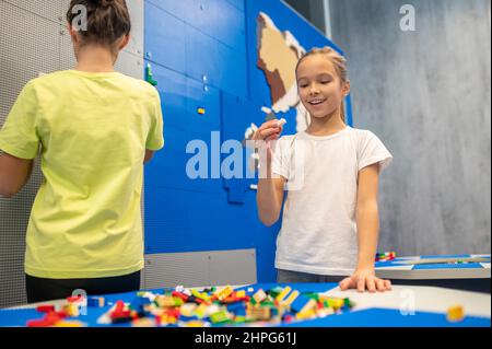 Mädchen freudig Blick auf Detail von lego Konstruktor Stockfoto