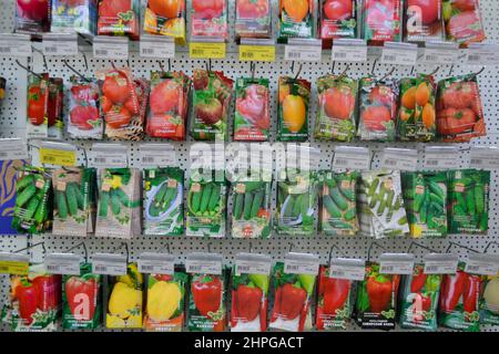 Moskau, Russland, Dezember 2019: Nahaufnahme eines Stands mit Papiertüten mit Gemüsesamen: Tomaten, Gurken, Paprika. Verkauf im Laden. Stockfoto